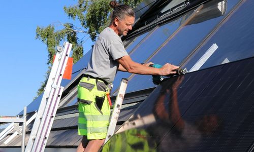 eza! Das Foto zeigt einen Handwerker bei der Montag eines PV-Moduls